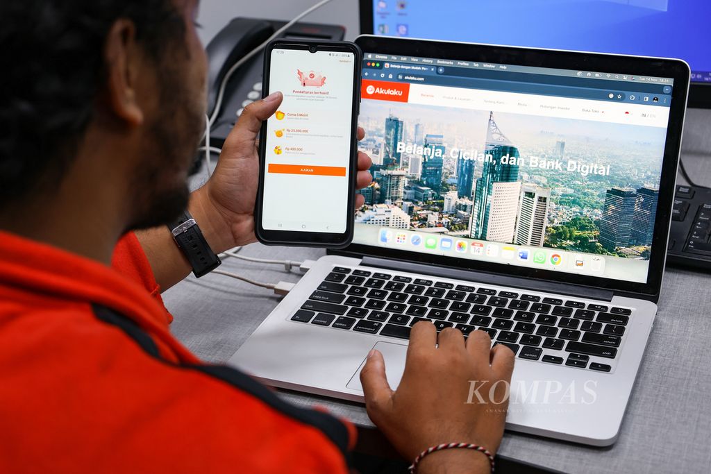 Warga mengakses aplikasi dan laman pinjaman daring di Jakarta, Selasa (14/11/2023).