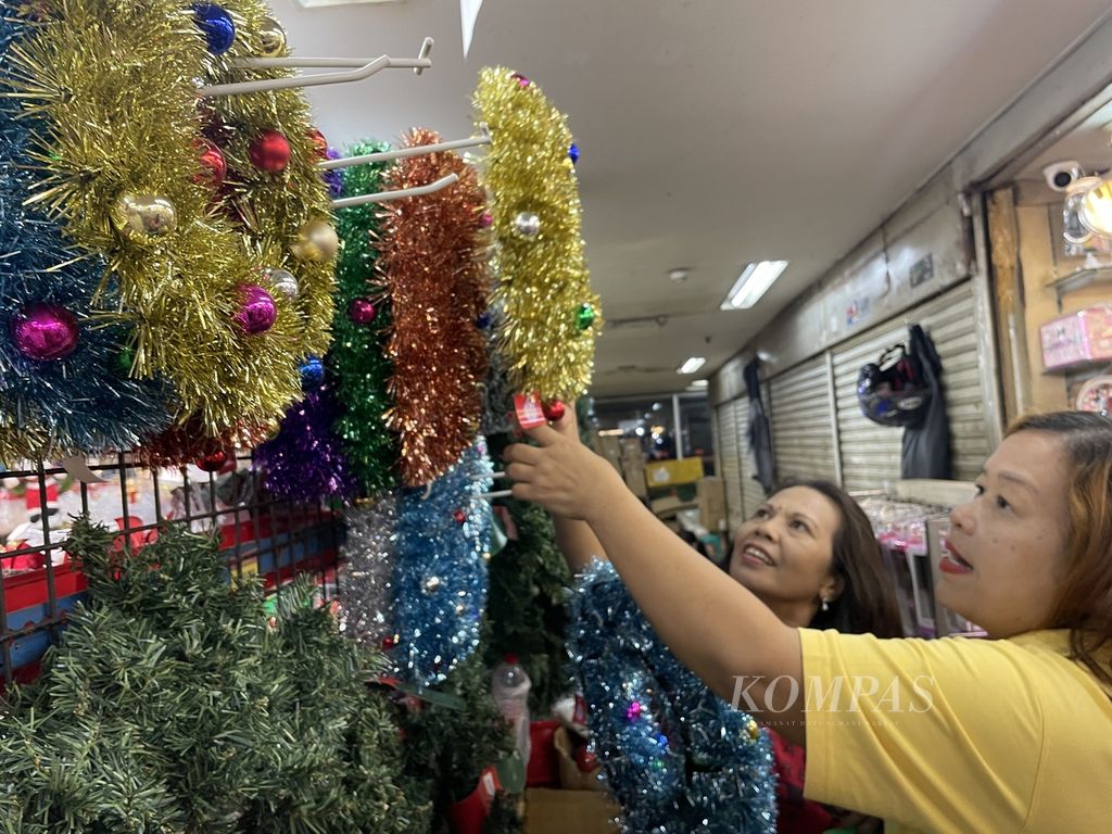 Pembeli memilih ornamen Natal di salah satu toko di Pasar Pagi Mangga Dua, Jakarta Utara, Senin (12/12/2023). Mereka berburu pernak-pernik Natal sekaligus berburu diskon.