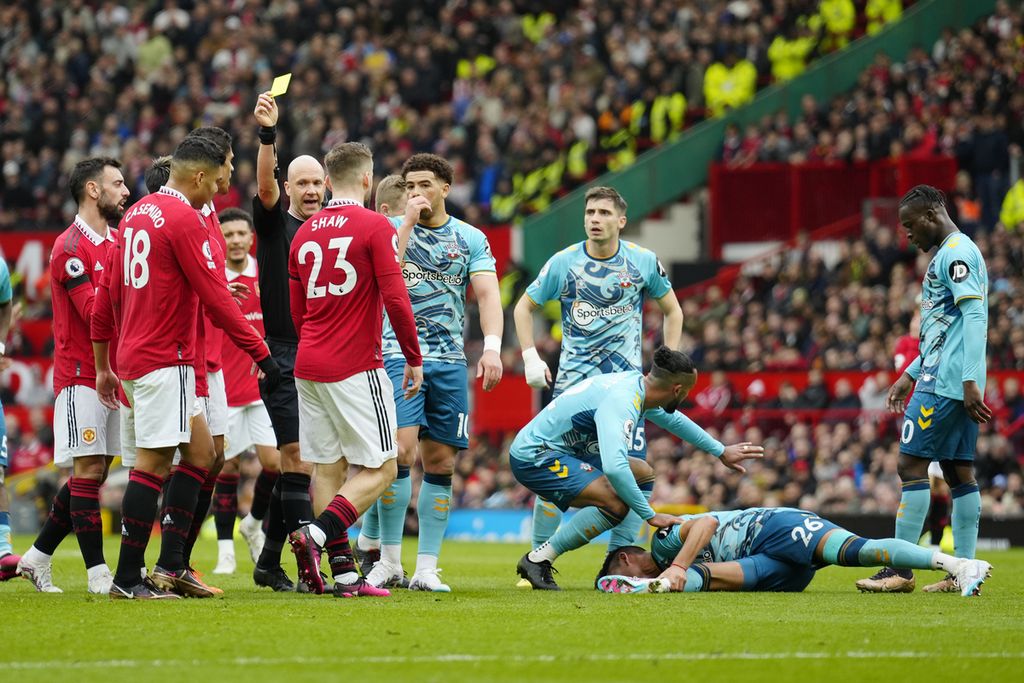 Wasit Anthony Taylor (keempat dari kiri) semula memberi hukuman kartu kuning kepada gelandang Manchester United, Casemiro (kedua dari kiri), yang melanggar pemain Southampton, Carlos Alcaraz (terjatuh), pada laga Liga Inggris antara MU dan Southampton di Stadion Old Trafford, Manchester, 12 Maret 2023.
