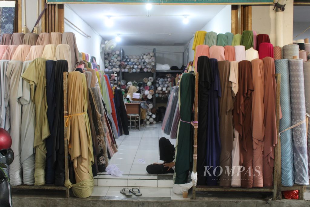 Pegawai salah satu toko di Kawasan Tekstil Cigondewah, Kota Bandung, Jawa Barat, tampak duduk santai menunggu pengunjung, Kamis (29/2/2024). 