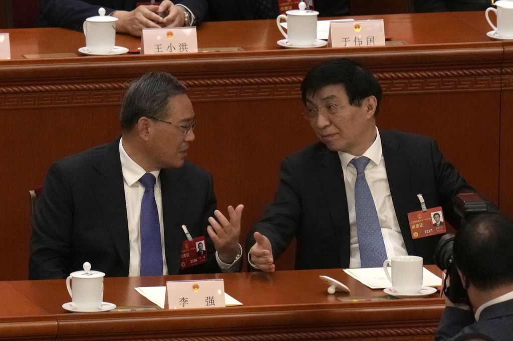 Perdana Menteri China Li Qiang (kiri) berbincang dengan Wang Huning saat sesi Kongres Rakyat Nasional China di Aula Besar Rakyat di Beijing, 12 Maret 2023. 