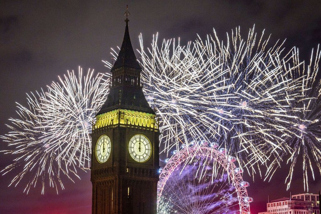 Kembang api menerangi langit di atas London Eye dan Elizabeth Tower, juga dikenal sebagai "Big Ben", di pusat kota London, Inggris, saat perayaan Tahun Baru pada Minggu 1 Januari 2023. 