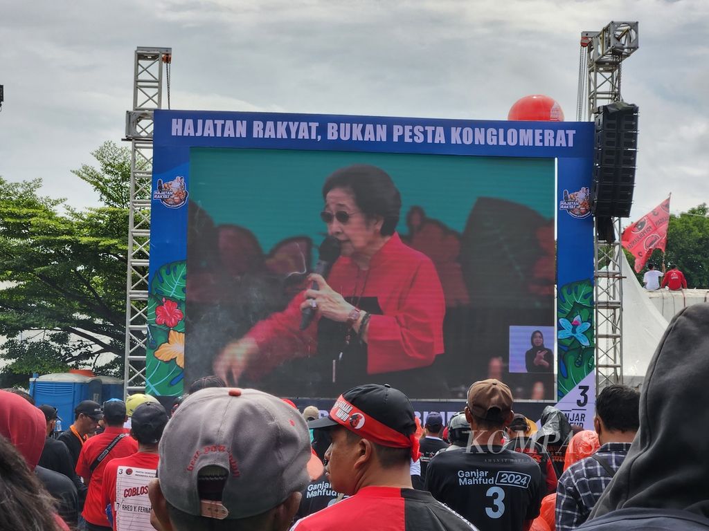 Warga menyaksikan Ketua Umum PDI-P Megawati Soekarnoputri sedang berpidato dari layar yang terpampang dalam kampanye pamungkas pasangan capres dan cawapres nomor urut 3, Ganjar Pranowo-Mahfud MD, di Benteng Vastenburg, Kota Surakarta, Jawa Tengah, Sabtu (10/2/2024).
