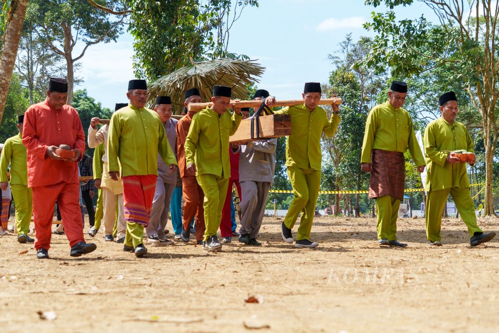 Tiang Tuo yang terbuat dari kayu bulian dibawa oleh pemangku adat dalam prosesi tradisi Tegak Tiang Tuo atau peletakan batu pertama pembangunan Museum KCBN Muarajambi di Desa Danau Lamo, Kecamatan Maro Sebo, Kabupaten Muaro Jambi, Jambi, Rabu (5/6/2024). 