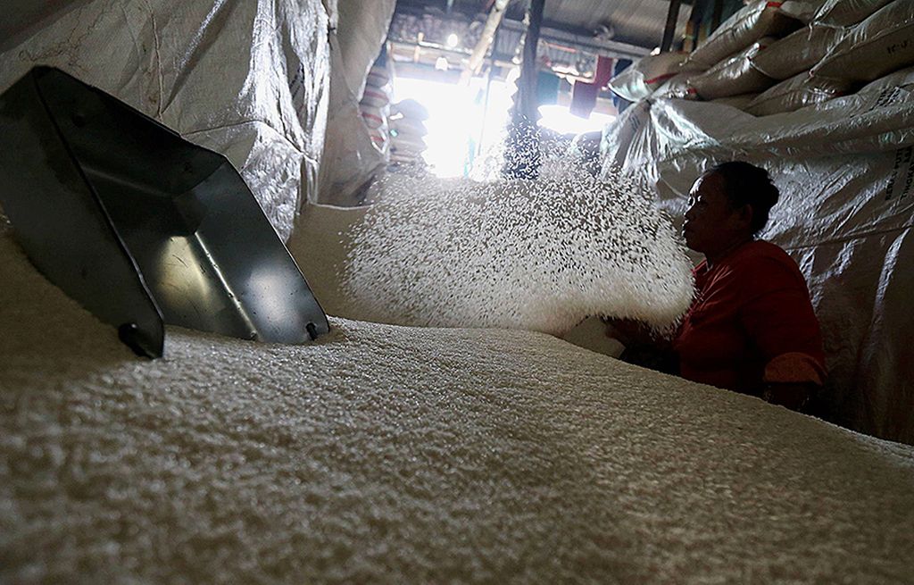 Buruh mengaduk beras yang baru tiba di Pasar Induk Beras Cipinang, Jakarta, Jumat (28/7). Seminggu terakhir ini, pasokan beras dari daerah yang masuk ke Cipinang berkurang hingga separuhnya. Penetapan harga eceran tertinggi  beras (HET) Rp 9.000 per kg, menuai protes dari para pedagang beras.