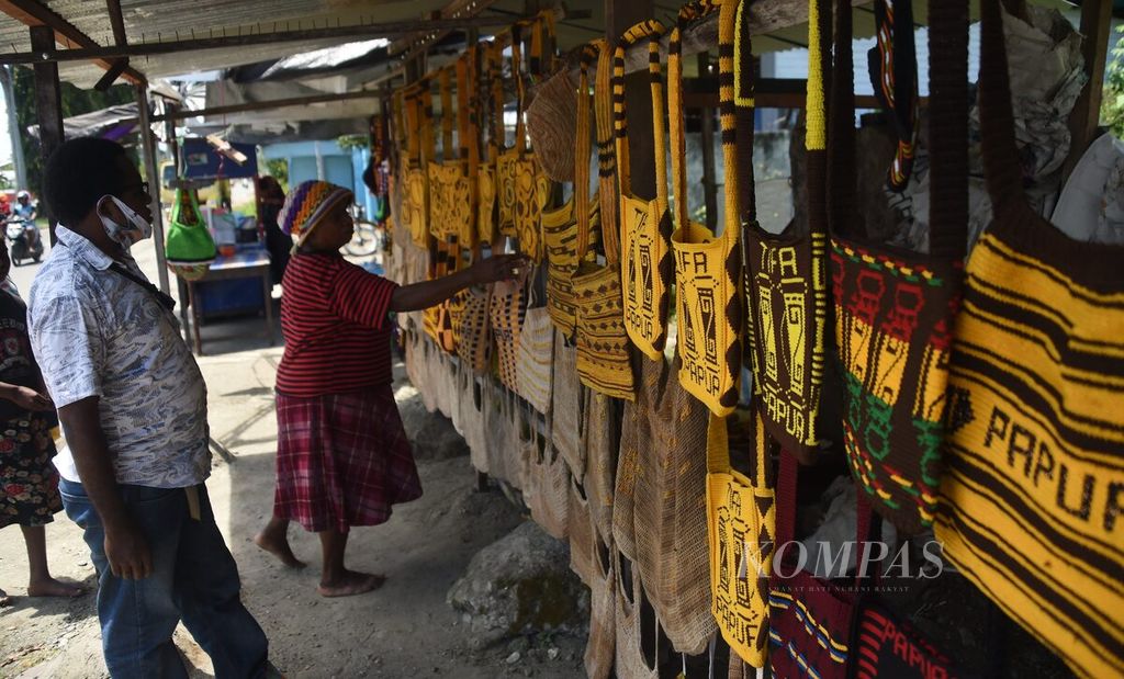 Wisatawan memilih noken di sentra penjualan noken di Jalan Yos Sudarso, Kabupaten Nabire, Papua, Rabu (28/4/2021). 