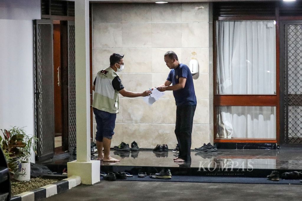 Penyidik Komisi Pemberantasan Korupsi (KPK) memberikan kertas kepada penjaga rumah dinas Menteri Pertanian Syahrul Yasin Limpo di Jalan Widya Chandra V, Jakarta Pusat, Kamis (28/9/2023). KPK menggeledah rumah tersebut.