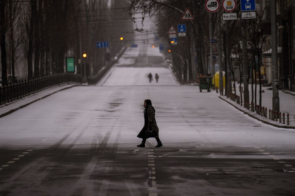Warga berjalan di jalan utama kota Kiev yang lengang saat jam malam diberlakukan di kota itu. Foto diambil pada Selasa (1/3/2022).