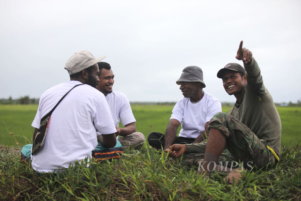 Petani berbincang di pinggir sawah di Kampung Waninggap Kai, Distrik Semangga, Kabupaten Merauke, Papua Selatan, Selasa (23/7/2024). Semangga merupakan salah satu daerah pertanian yang cukup besar di Merauke. 