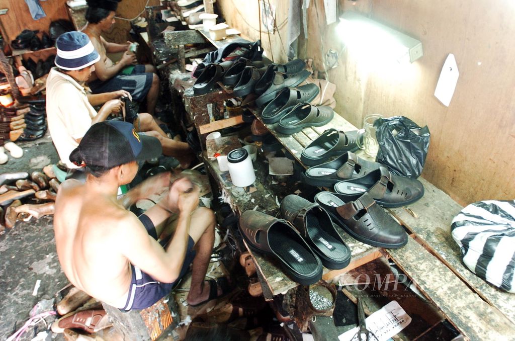 Seorang karyawan industri sepatu kecil di kawasan Jalan Batik Gayam, Semarang, Kamis (24/3/2004), tengah menyelesaikan pekerjaannya. Meski tanpa dukungan pemerintah, usaha kecil milik Kurdi ini mampu memproduksi 3.000 pasang sepatu dan sandal kulit dalam berbagai model. Harga produknya pun variatif, paling murah untuk sepasang sandal dijual Rp 30.000 dan untuk sepatu Rp 80.000.