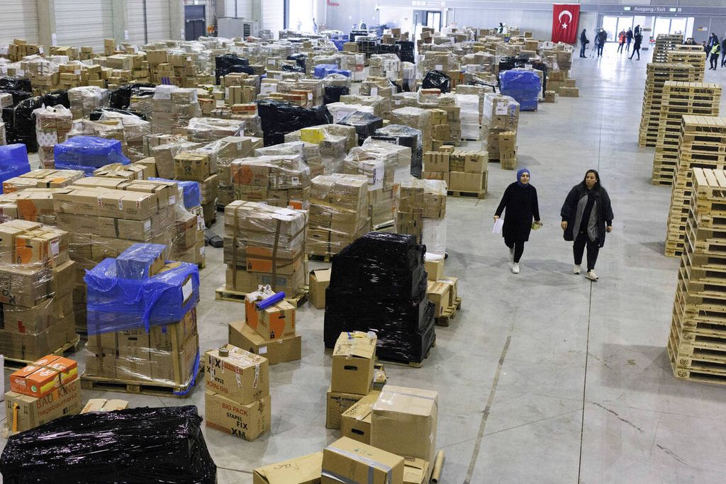 Sukarelawan berjalan di antara paket berisi sumbangan untuk korban gempa bumi Turki yang diletakkan di dekat Bandara Berlin-Brandenburg, 9 Februari 2023.