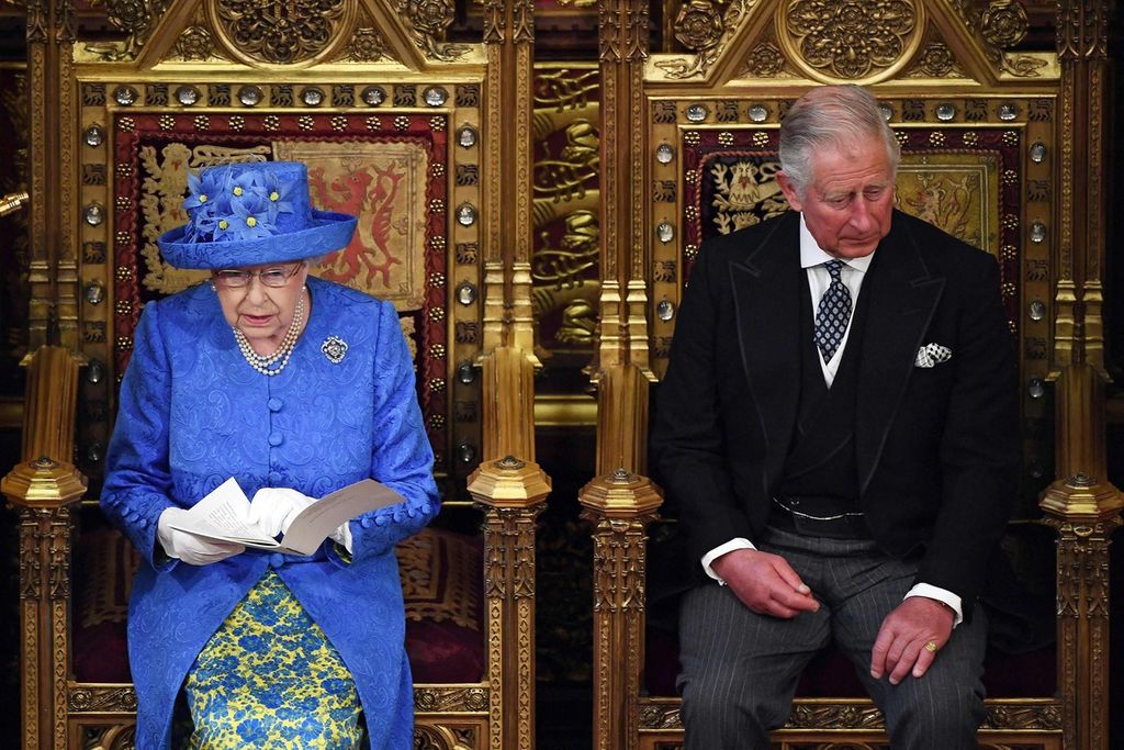 Foto yang diambil per 21 Juni 2017 ini menunjukkan Ratu Elizabeth II duduk di samping putranya, Pangeran Charles saat membacakan pidato pada pembukaan masa sidang parlemen di Gedung Parlemen Inggris, di London. 