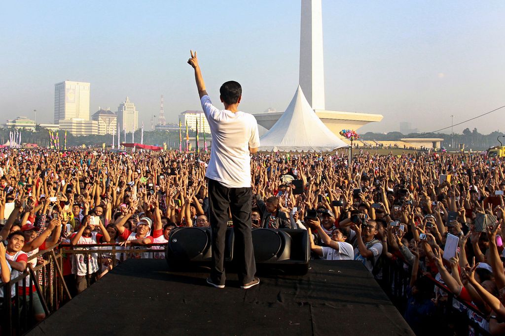 Presiden Jokowi melepas ribuan peserta acara Gerak Jalan Revolusi Mental di kawasan Monas, Jakarta, Minggu (22/6/2014). Pesiden Joko Widodo tercatat beberapa kali mengeluarkan pernyataan yang dimaknai sebagai bentuk mempromosikan <i>(endorsement)</i> tokoh-tokoh yang berpotensi maju sebagai calon presiden. Hasil survei <i>Kompas </i>merekam, respons publik pada dukungan presiden ini tetap bergantung pada sejauh mana kepuasan mereka pada kinerja pemerintahan Jokowi selama ini.