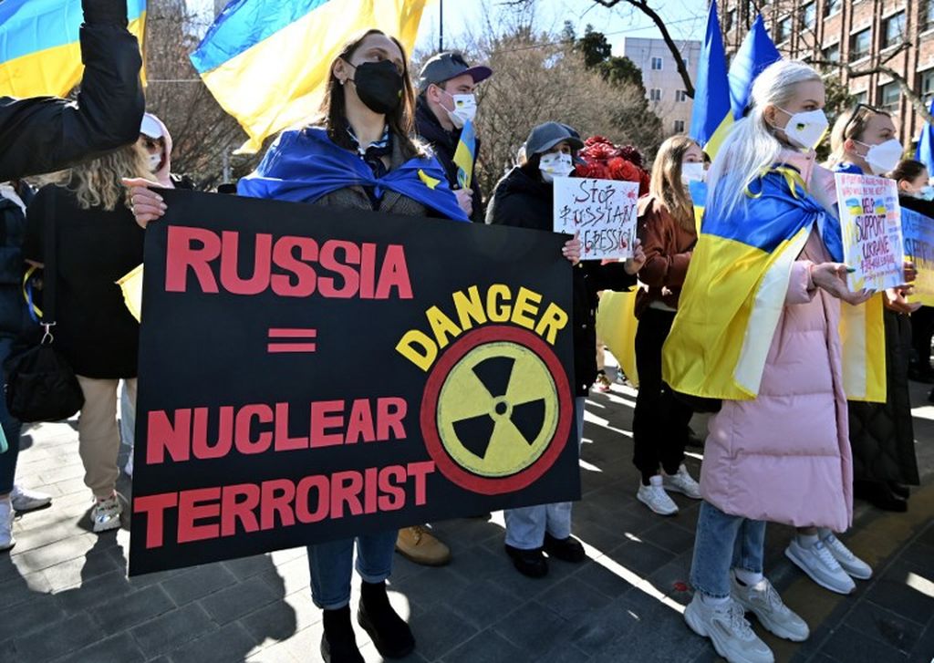  Warga Ukraina yang tinggal di Korea Selatan dan para pendukung mereka memegang poster atau plakat saat menggelar unjuk rasa menentang invasi Rusia ke Ukraina di dekat Kedutaan Besar Rusia di Seoul, Minggu, 6 Maret 2022. 
