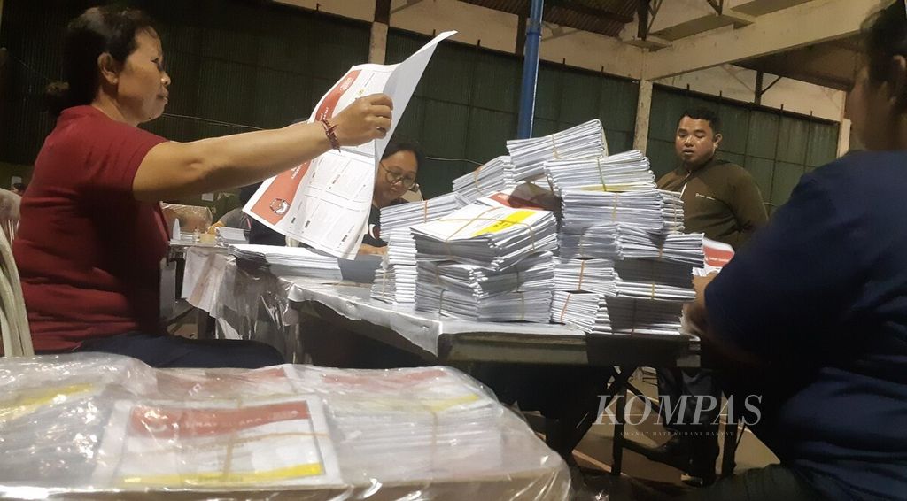 Tenaga sukarelawan pelipat surat suara memeriksa sebelum melipat surat suara, yang nantinya akan digunakan dalam Pemilu 2024, di gudang logistik KPU Kota Denpasar yang berlokasi di GOR Kompyang Sujana, Kota Denpasar, Bali, Rabu (13/12/2023).