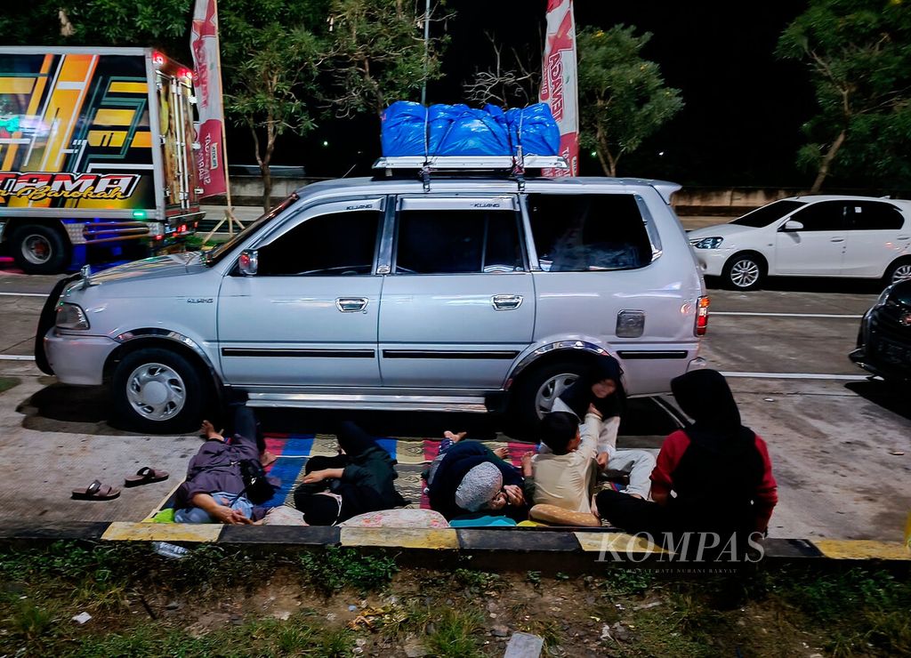 Keluarga pemudik menyempatkan istirahat setelah melakukan perjalanan melintasi jalan tol Cikampek-Batang saat singgah di tempat istirahat di Kabupaten Brebes, Jawa Tengah, Jumat (29/4/2022). 