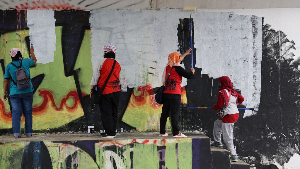 Pekerja rumah tangga (PRT) mengecat tembok penyangga jembatan yang akan dilukisi mural di Jembatan Kewek, Kotabaru, Yogyakarta, Rabu (15/12/2021). Mereka menggelar aksi untuk memprotes pembahasan RUU Perlindungan Pekerja Rumah Tangga yang masih terkatung-katung selama belasan tahun. Aksi itu juga sebagai wujud protes terhadap masih sering terjadinya tindakan kekerasan yang dilakukan majikan terhadap PRT. Mereka juga menuntut pemenuhan sejumlah hak mereka melalui aksi itu.