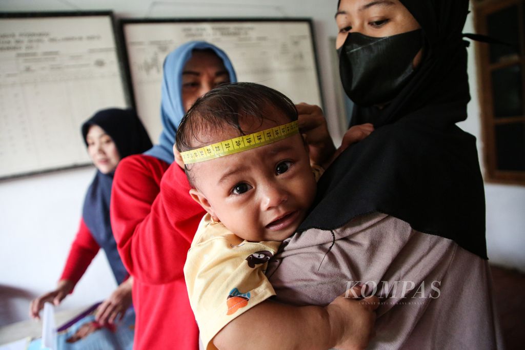 Seorang anak balita diukur lingkar kepalannya saat menjalani pemeriksaan bulanan di Posyandu Kemuning di Larangan, Kota Tangerang, Banten, Senin (13/2/2023). Sekitar 100 bayi dan anak balita terdaftar di posyandu tersebut.