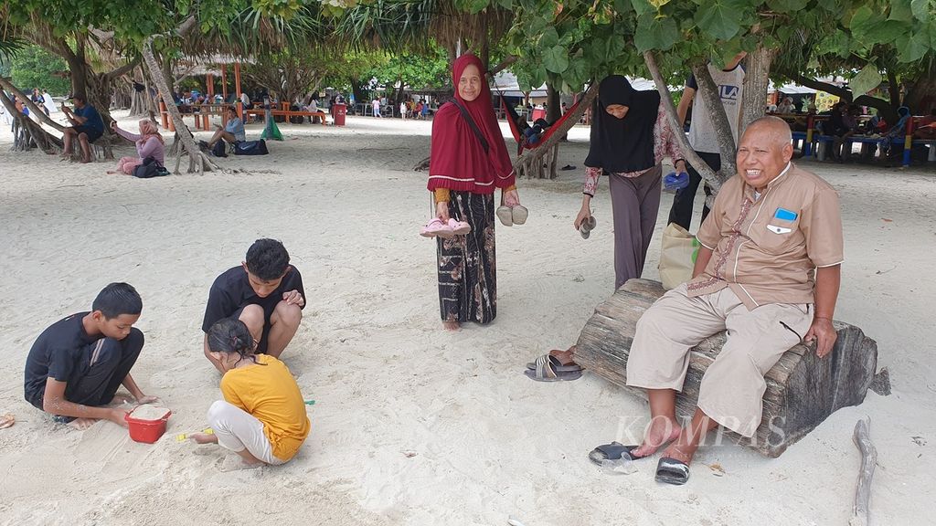 Ahmad Hanafiah (paling kanan), warga Bogor, Jawa Barat bersama istri, anak, dan cucunya menghabiskan waktu libur lebaran di Pulau Pari, Kabupaten Kepulauan Seribu, Jakarta, Minggu (14/4/2024).