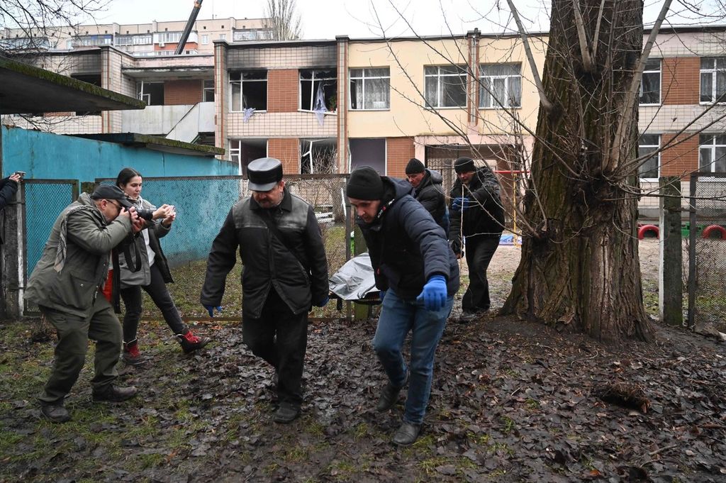 Empat pria menandu jenazah korban kecelakaan helikopter yang menewaskan Menteri Dalam Negeri Ukraina Denys Monastyrskyi di dekat sebuah taman kanak-kanak di luar ibu kota Kyiv, Ukraina, Rabu (18/1/2023). 