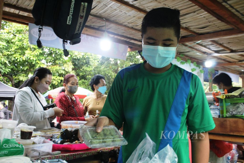 Ridwan (15), salah satu pedagang wadai, menunjukkan tapai gambut hijau yang juga jadi andalannya untuk dijual di Pasar Wadai, Kota Palangkaraya, Kalimantan Tengah, Selasa (5/4/2022). 