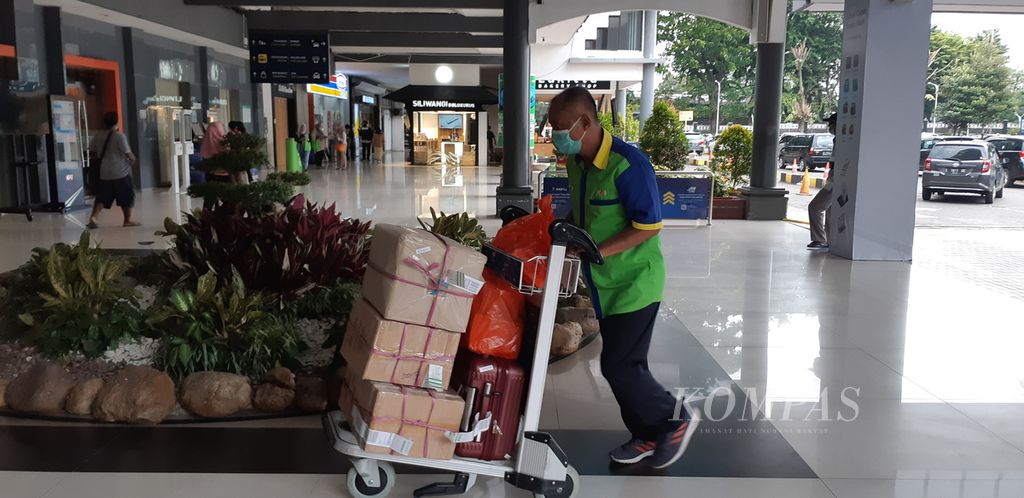 Seorang porter di Stasiun Gubeng, Surabaya, Jawa Timur, membawa barang bawaan penumpang kereta api, Senin (6/3/2023). Mereka biasanya menerima upah Rp 20.000 hingga Rp 50.000 untuk jasa pelayanan yang diberikan.