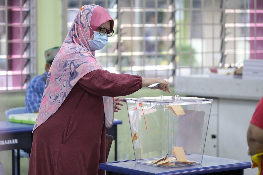 Seorang pemilih memasukkan kertas suara ke dalam kotak di tempat pemungutan suara di Selayang, pinggiran Kuala Lumpur, Malaysia, 12 Agustus 2023. Pemilu di enam negara bagian ini dinilai sebagai ujian bagi pemerintahan Perdana Menteri Anwar Ibrahim, 
