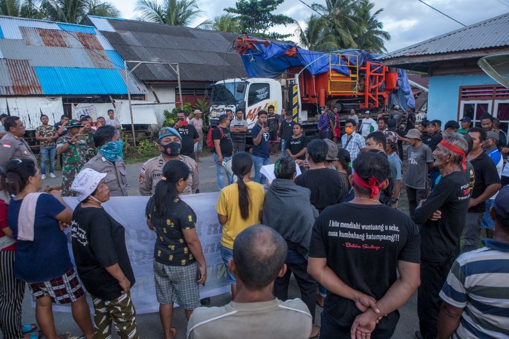 Warga Kampung Bowone dan Binebas memblokade jalan untuk menghalangi akses alat berat pertambangan milik PT TMS di Kepulauan Sangihe, Sulawesi Utara, pada Kamis (16/6/2022).