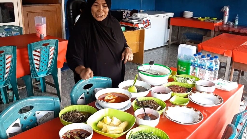 Mama Salma Baya (58) tengah menyiapkan seperangkat papeda dan menu pendamping di warung miliknya di Daruba, Kabupaten Pulau Morotai, Maluku Utara, akhir Juli 2022.