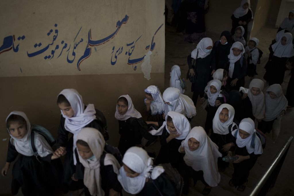 Siswi perempuan menaiki tangga sekolah mereka menuju ruang kelas masing-masing di sebuah sekolah di Kabul, Afghanistan, Minggu (12/9). (AP Photo/Felipe Dana)