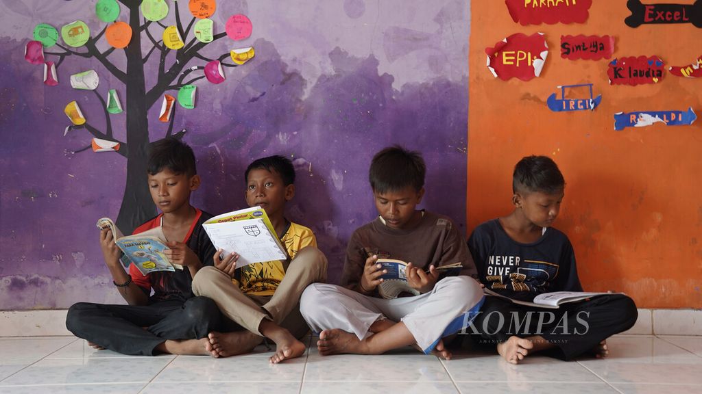 Anak-anak membaca buku koleksi perpustakaan di Rumah Belajar Anak Bintang di Desa Pantai Mekar, Kecamatan Muaragembong, Kabupaten Bekasi, Jawa Barat, Rabu (26/10/2022). Sebanyak 50 anak-anak yatim dan duafa dari kelas IV SD hingga kelas 3 SMP belajar sepulang sekolah di tempat tersebut. 