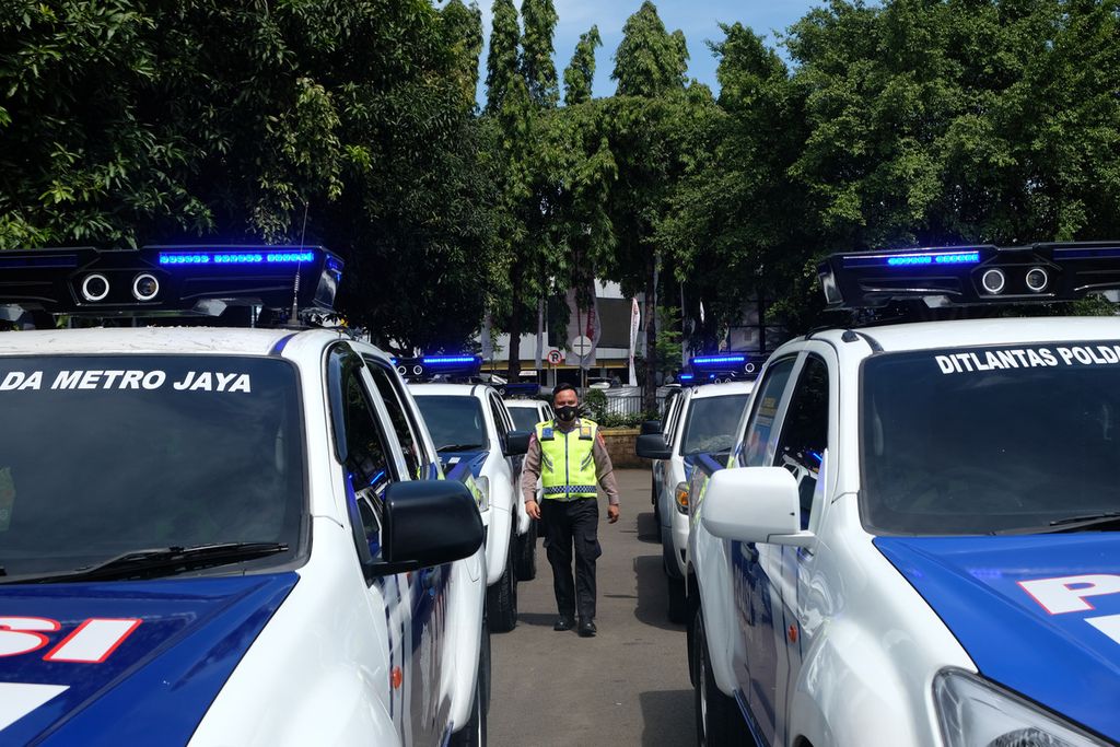 Polisi berjalan di antara mobil patroli yang terpasang kamera untuk <i>electronic traffic law enforcement </i>(ETLE) <i>mobile</i> atau tilang bergerak dalam acara peluncuran ETLE <i>mobile</i> di Lapangan Ditlantas Polda Metro Jaya, Jakarta Selatan, Selasa (13/12/2022). Kepolisian Resor Cianjur tengah mengusut kecelakaan lalu lintas yang menelan korban jiwa dan melibatkan mobil diduga ikut konvoi kendaraan Polda Metro Jaya.