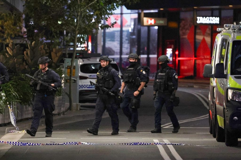 Polisi bersenjata lengkap berpatroli di depan Mal Westfield Bondi Junction, Sydney setelah insiden penikaman yang menewaskan enam orang di mal tersebut pada Sabtu 13/4/2024).