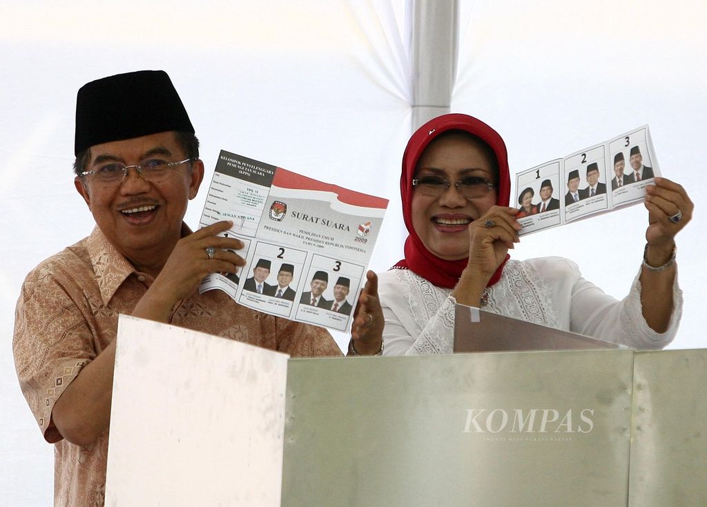 Calon presiden Jusuf Kalla bersama Ibu Mufidah Jusuf Kalla menunjukkan surat suara di TPS 19, Taman Suropati, Menteng, Jakarta, Rabu (8/7/2009). 