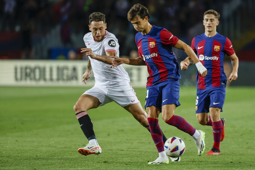 Pemain Barcelona, Joao Felix (tengah), berebut bola dengan pemain Sevilla, Lucas Ocampos, dalam Liga Spanyol di Stadion Olimpic Lluis Companys, Barcelona, Sabtu (30/9/2023) dini hari WIB. Barcelona menang 1-0 pada laga itu.