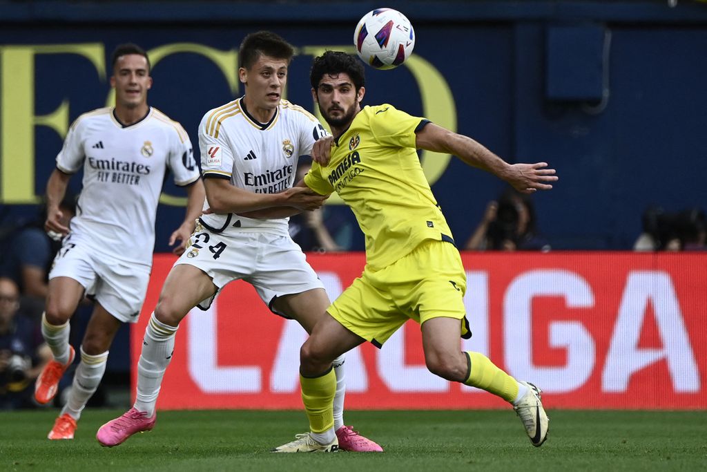 Real Madrid's Arda Guler (center) and Villarreal's Goncalo Guedes fight for the ball during a Spanish League match at La Ceramica Stadium, in Villarreal, Spain, Sunday (5/19/2024).  The game ended in a 4-4 tie.