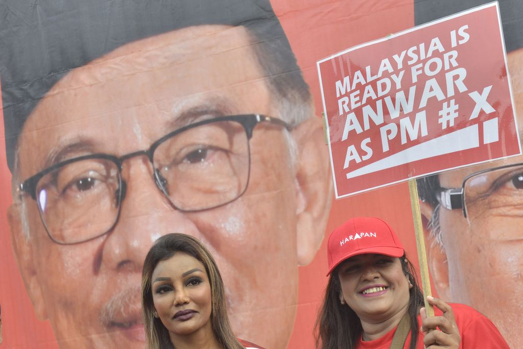 Pendukung tokoh oposisi Malaysia Anwar Ibrahim membawa poster dukungan terhadap Anwar di pusat pendaftaran pemilu di Tambun, Malaysia, Sabtu (5/11/2022). 