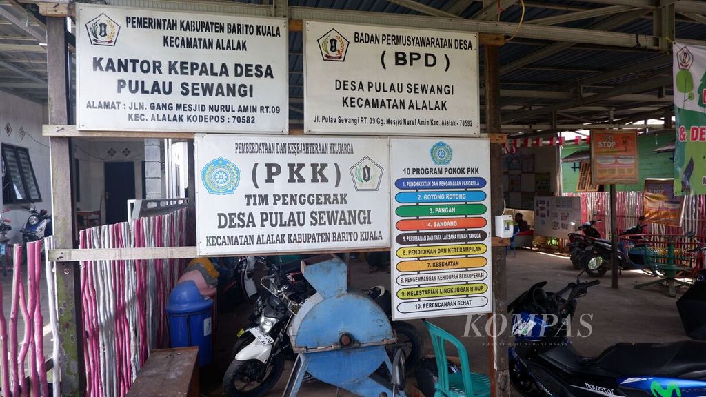 Plang nama di depan Balai Desa Pulau Sewangi, Kecamatan Alalak, Kabupaten Barito Kuala, Kalsel, Senin (23/10/2023). 