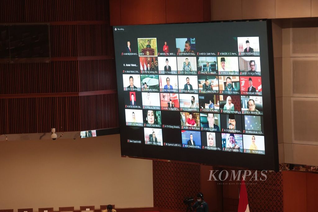 Monitor broadcasted members of parliament participating in a virtual plenary session at the Parliament Complex in Senayan, Jakarta on Tuesday (1/11/2022). A total of 91 individuals attended the plenary session in person, 218 attended virtually, and 45 had permission to be absent.