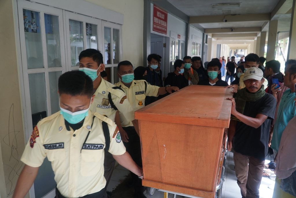 Petugas keamanan RSUD dr Achmad Mochtar Bukittinggi dibantu pihak keluarga mengangkat peti jenazah korban erupsi Gunung Marapi untuk dibawa pulang dengan ambulans, Bukittinggi, Sumatera Barat, Rabu (6/12/2023). 