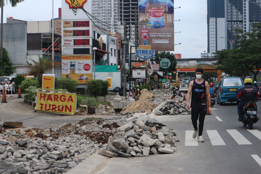 Seorang pejalan kaki terpaksa berjalan di jalan raya karena proses revitalisasi trotoar di Jalan Margonda Raya, Depok, Kamis (10/11/2022). Trotoar ini sedang direvitalisasi oleh Pemkot Depok. Trotoar di sepanjang Jalan Margonda Raya ini akan diperlebar 4 meter.