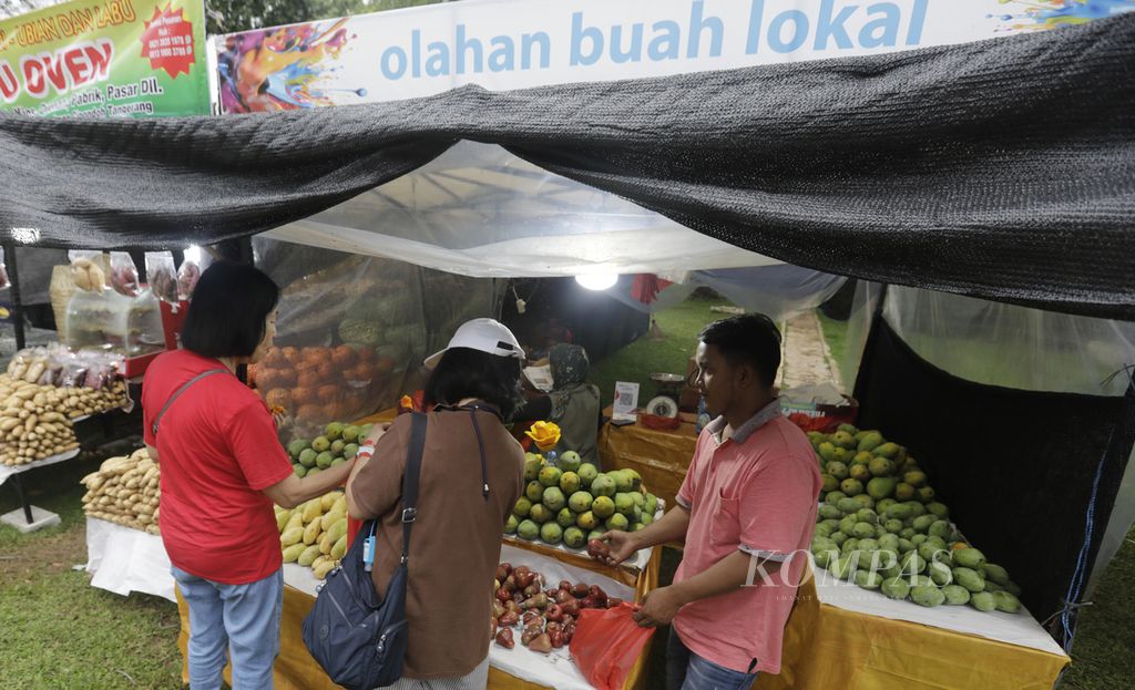 Pengunjung berburu buah di stan buah-buahan lokal dalam Pameran Flona (Flora dan Fauna) 2024 di Taman Lapangan Banteng, Jakarta Pusat, Jumat (5/7/2024). 