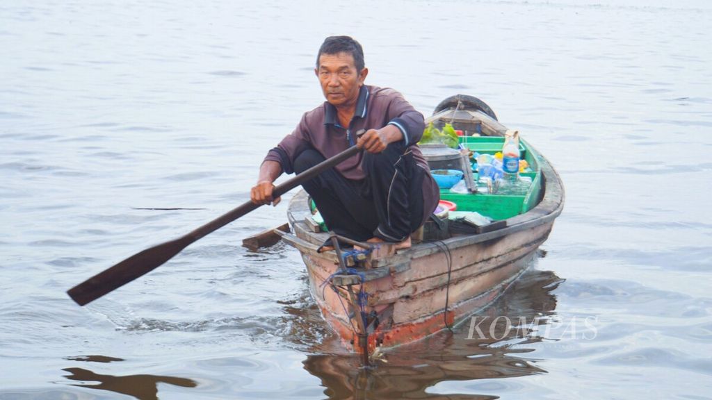 Arbain (67), pedagang Pasar Tarapung Muara Kuin, mengayuh dayung di Sungai Barito untuk menuju Dermaga Pasar Terapung Muara Kuin, Banjarmasin,  Sabtu (9/9/2023). 