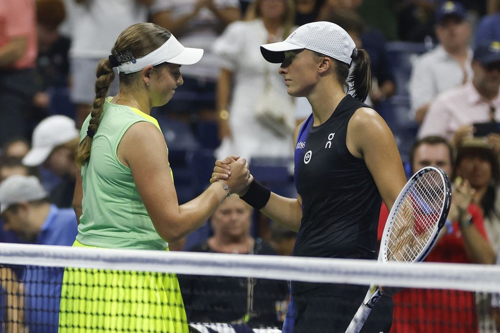 Jelena Ostapenko (kiri) bersalaman dengan Iga Swiatek usai laga laga babak keempat Grand Slam AS Terbuka di Pusat Tenis Nasional Billie Jean King, New York, Minggu (3/9/2023).
