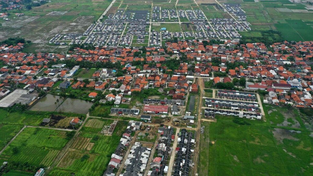 Foto aerial perumahan warga di antara areal persawahan di Tambun Utara, Kabupaten Bekasi, Jawa Barat, Kamis (13/2/2020). Potensi pengembangan properti di timur Jakarta, terutama Bekasi, mengalami kenaikan.