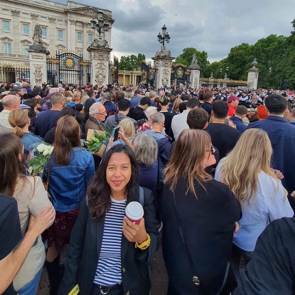 Wartawan harian <i>Kompas,</i> Denty Piawai Nastitie, saat meliput wafatnya Ratu Inggris Elizabeth II di depan kompleks Istana Buckingham, London, Inggris.