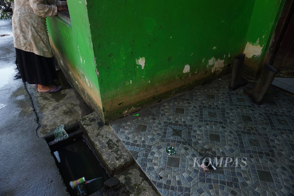 Sepasang sepatu bot diletakkan di depan rumah di Kelurahan Panjang Wetan, Kecamatan Pekalongan Utara, Kota Pekalongan, Jawa Tengah, Selasa (18/7/2023). Sepatu bot menjadi salah satu barang yang wajib dipunyai warga untuk melindungi kaki mereka dari air rob.