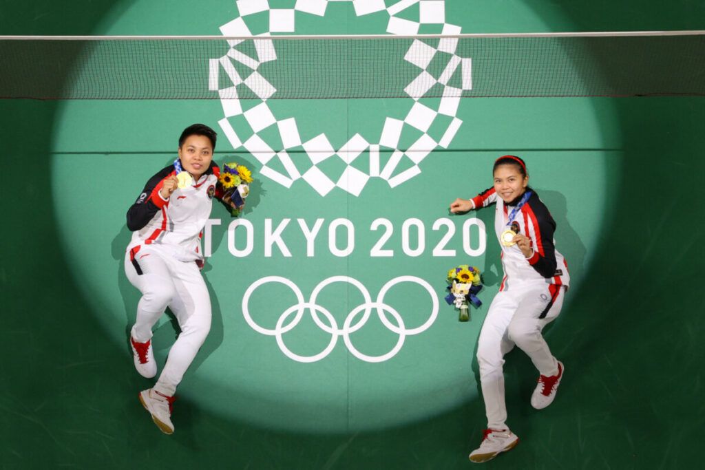 Atlet Indonesia Apriyani Rahayu (kiri) dan Greysia Polii Indonesia berpose di lapangan dengan medali emas bulu tangkis ganda putri Olimpiade Tokyo 2020 di Musashino Forest Sports Plaza di Tokyo pada 2 Agustus 2021.