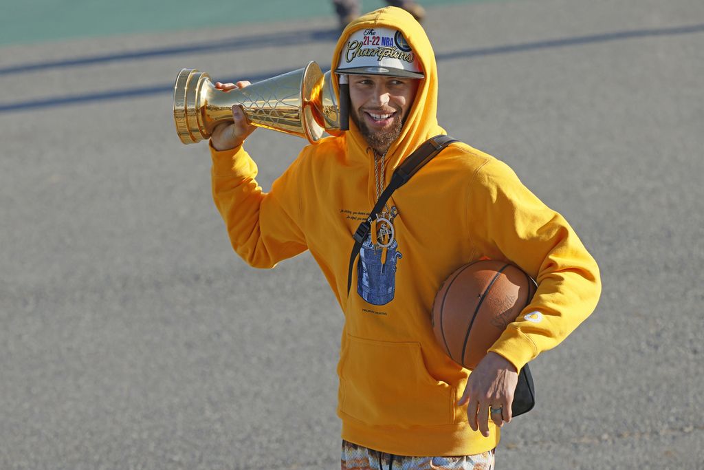 Bintang Golden State Warriors, Stephen Curry, membawa trofi MVP Final NBA saat bersama timnya tiba di bandara internasional San Francisco, Jumat (17/6/2022). Warriors kembali dari Boston sebagai juara NBA 2022 setelah mengalahkan Boston Celtics pada gim keenam, sehari sebelumnya.