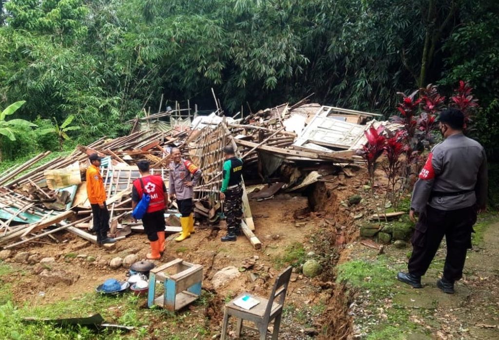 Petugas berada di depan rumah warga yang ambruk akibat bencana tanah bergerak di Desa Dermasuci, Kecamatan Pangkah, Kabupaten Tegal, Jawa Tengah Minggu (13/2/2022). Akibat kejadian itu, ratusan rumah rusak ringan hingga berat dan ratusan warga mengungsi.